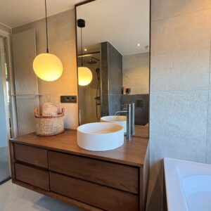 houten badkamer spiegel tegen plafond op maat, leunend op houten badkamermeubel in japandi badkamer