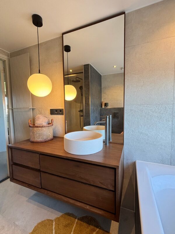 houten badkamer spiegel tegen plafond op maat, leunend op houten badkamermeubel in japandi badkamer