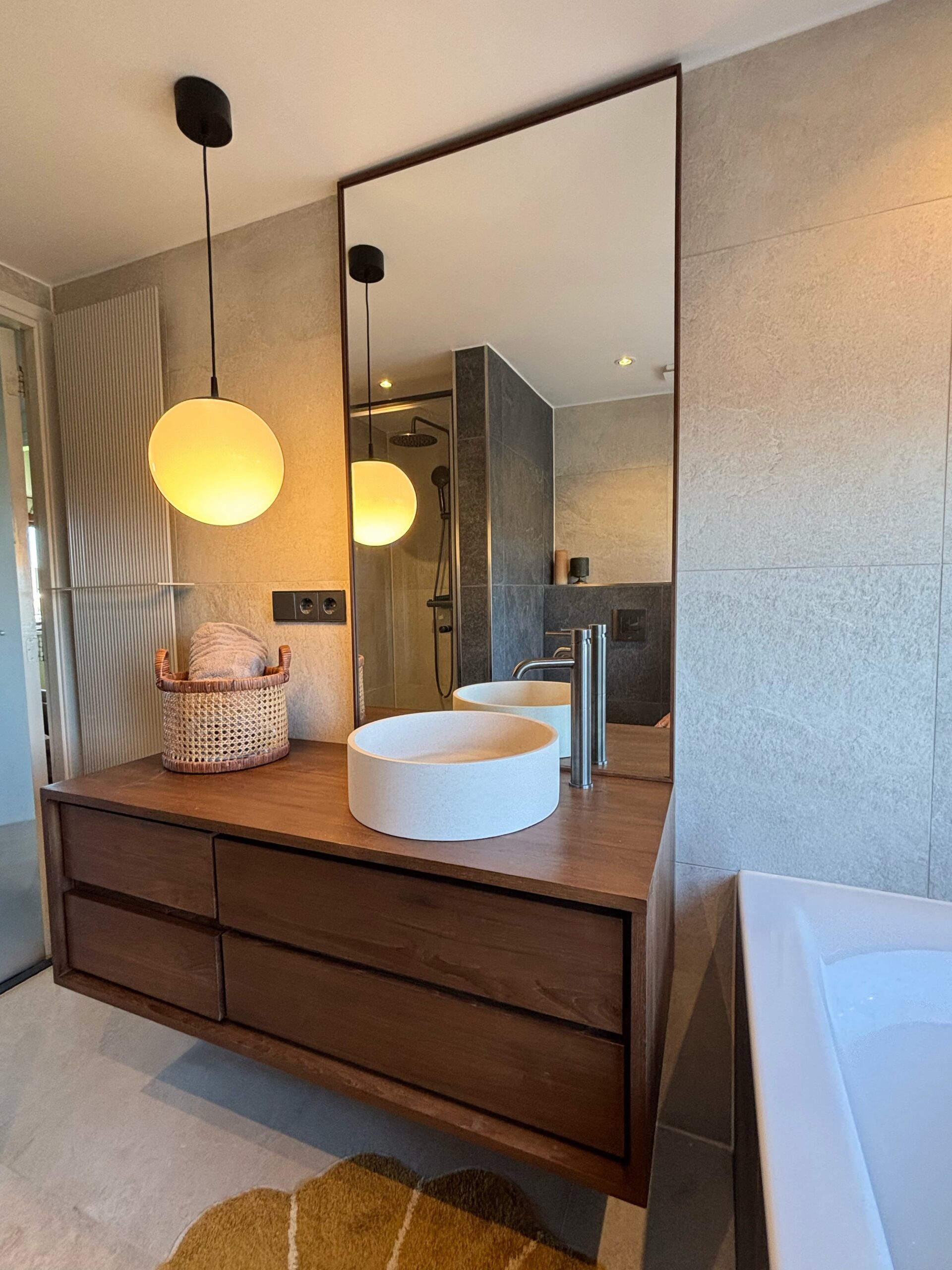 houten badkamer spiegel tegen plafond op maat, leunend op houten badkamermeubel in japandi badkamer