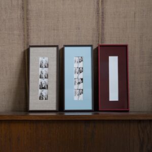 Drie ingelijste fotostrips photobooth lijsten met linnen passe-partout en dunne houtnerf lijst in taupe, lichtblauw en bordeauxrood