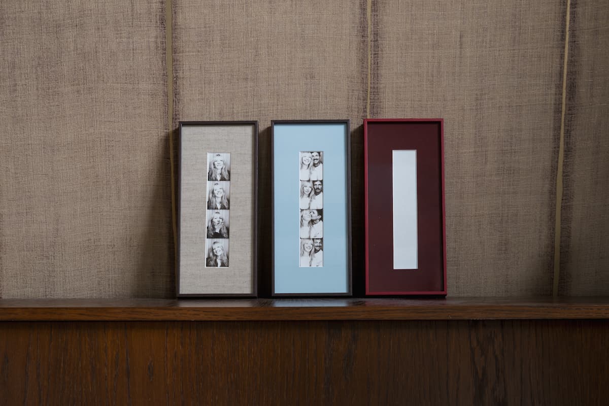 Drie ingelijste fotostrips photobooth lijsten met linnen passe-partout en dunne houtnerf lijst in taupe, lichtblauw en bordeauxrood